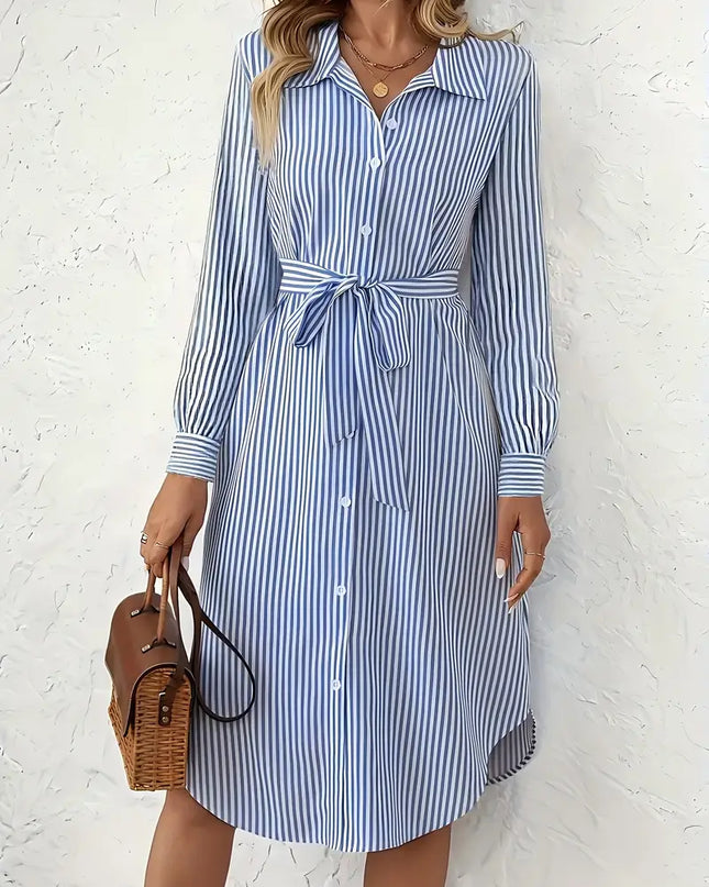 Woman wearing a blue and white striped dress against a white background