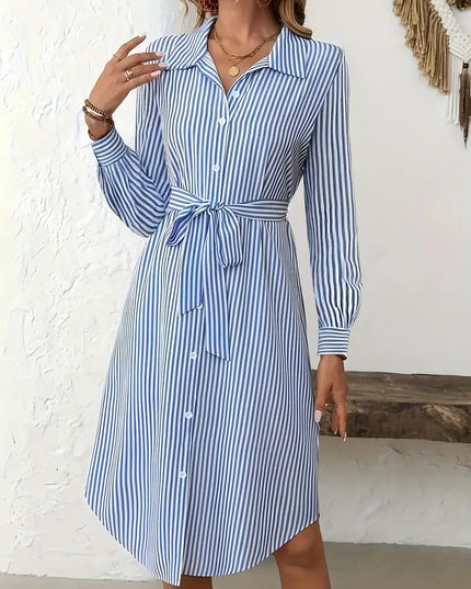 Woman wearing a blue and white striped dress against a white background
