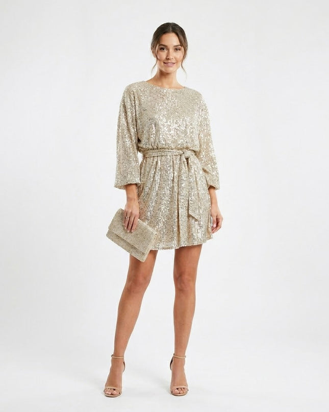 Woman wearing sparkling sequin mini dress with waist tie detail