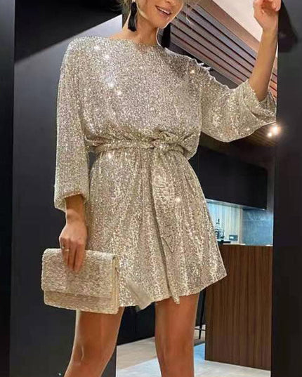 Woman wearing sparkling sequin mini dress with waist tie detail