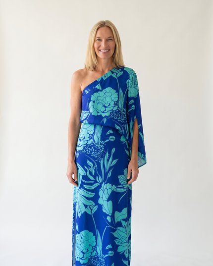 Woman wearing one-shoulder floral maxi dress with flowing silhouette